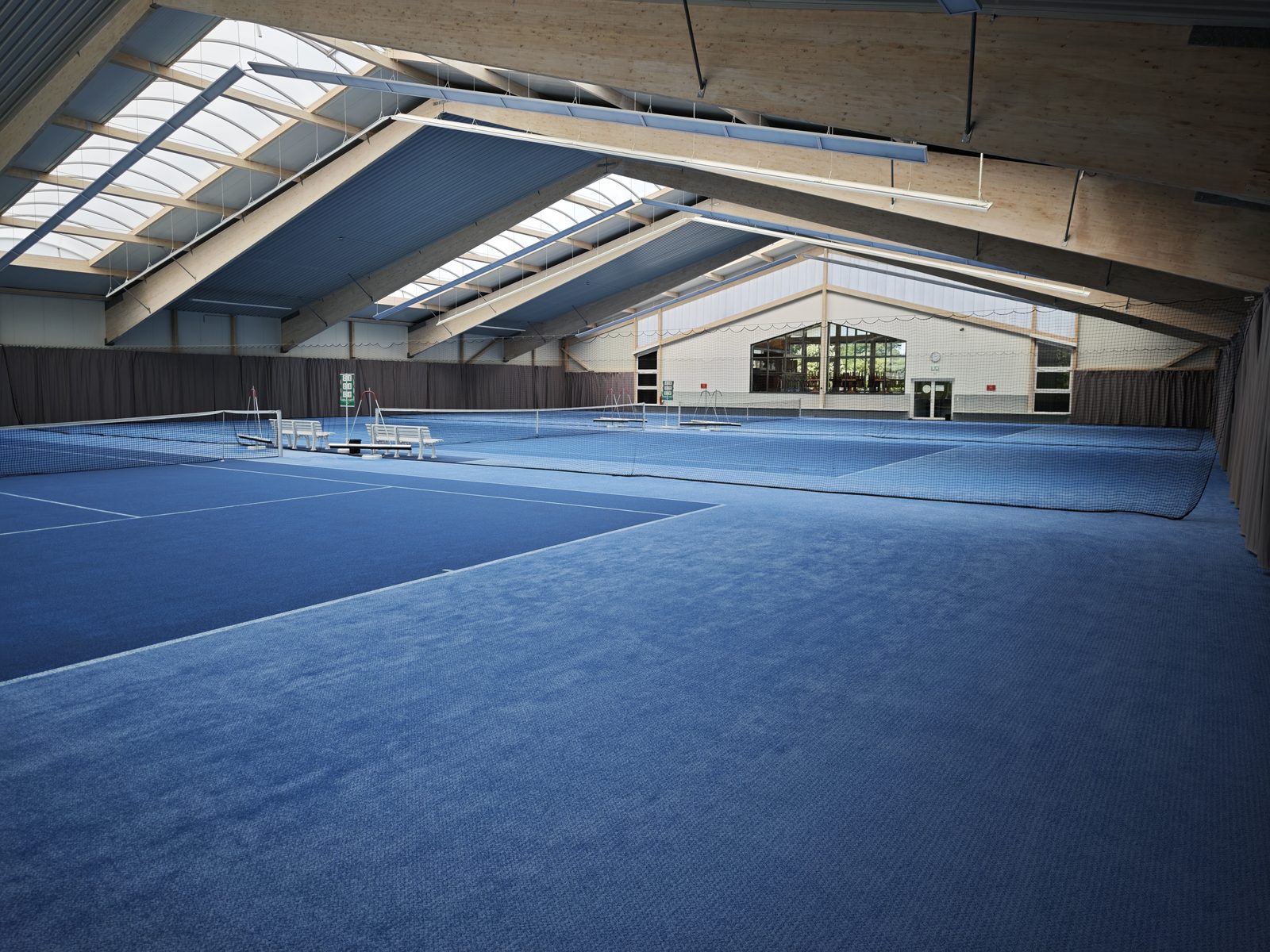 Innenansicht der Dreifeld-Tennishalle des TSV Rohr mit neuem Boden und neuen LED-Lichtbändern