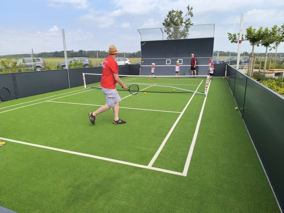 Spielszene auf dem Kleinfeld-Court des TSV Rohr: Erwachsene und Kinder mit Schlägern am Netz, dahinter die Ballwand